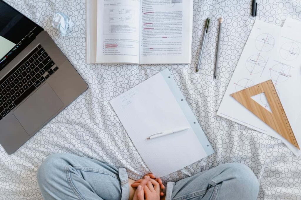 Person in Blue Denim Jeans Sitting Beside White Printer Paper