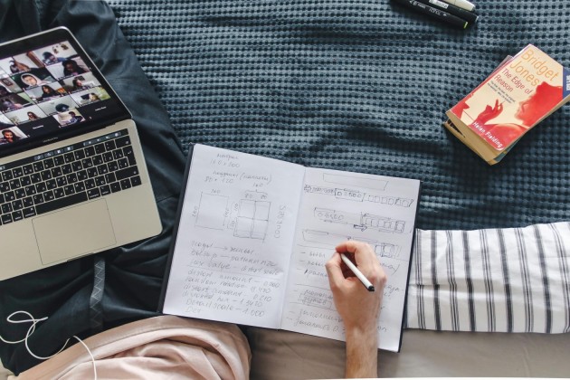 Student studying online with a laptop and notebook