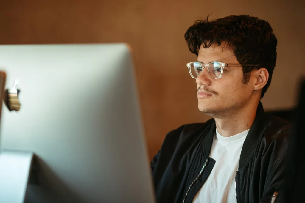 A young man using an Apple desktop