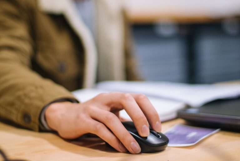 A focused student studying at a desk with a laptop and books in a cosy room.